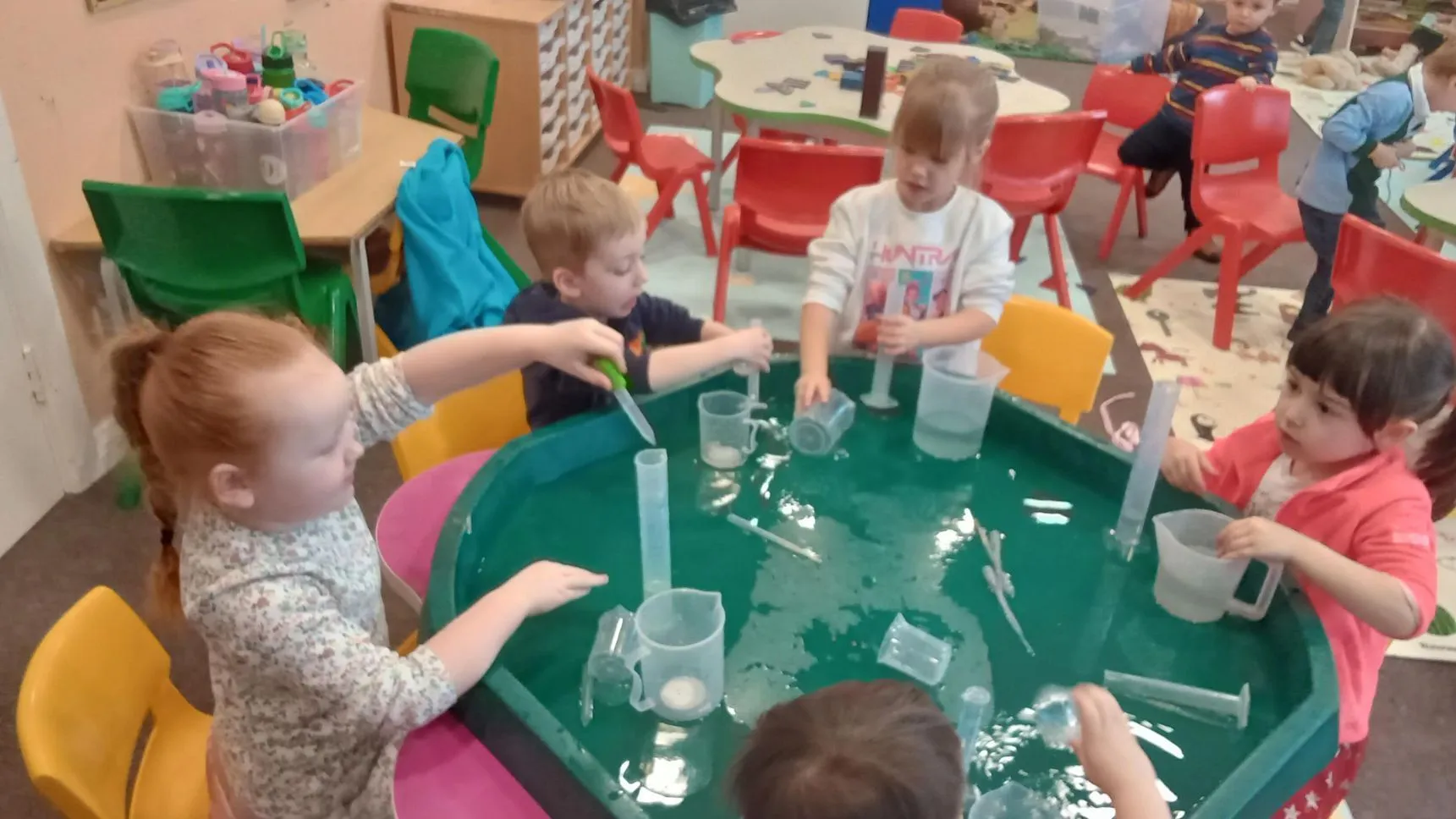 Preschool children exploring a water tray together at Ready Steady Go Childcare
