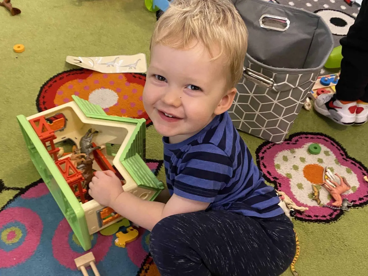 Nursery child smiling while playing in the playroom at Ready Steady Go Childcare Worle