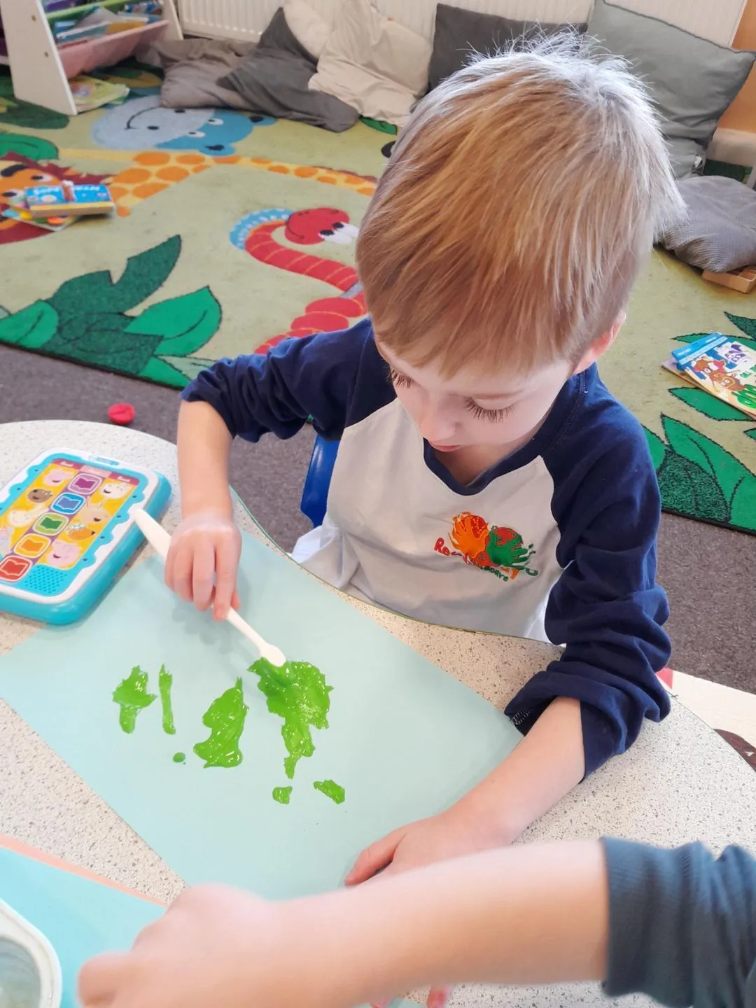 Preschool child painting at a table at the Ready Steady Go preschool in Milton